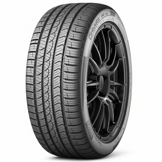 A black Pirelli Grappler VC all-weather tire mounted on a dark multi-spoke alloy wheel, shown from a three-quarter angle on a white background with a soft reflection.